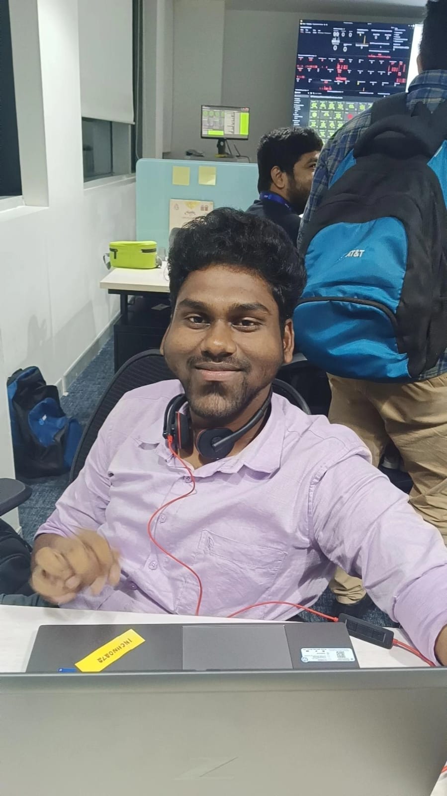 Rakesh seated alone at his desk, looking toward the camera