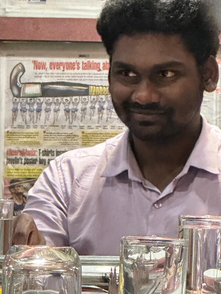 Rakesh seated alone at his desk in the office
